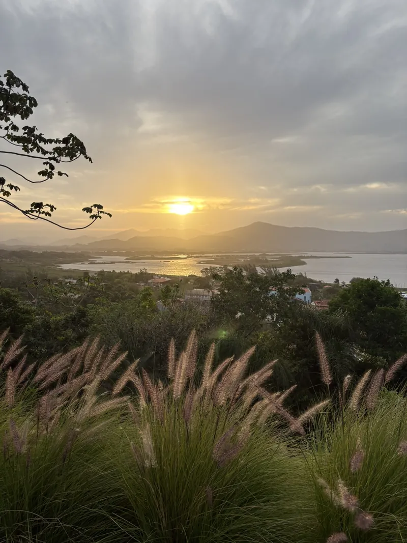 Pôr do sol sobre a Lagoa de Garopaba e as montanhas, visto do alto do morro