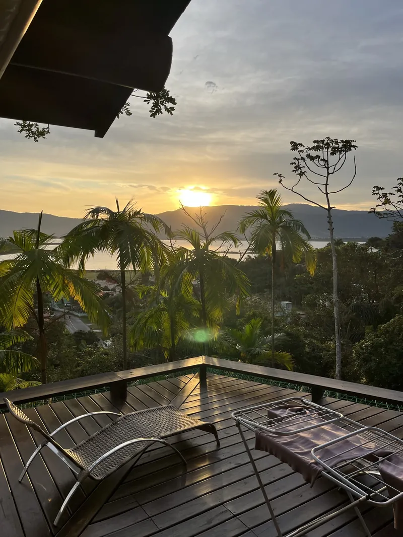 Pôr do sol sobre a Lagoa de Garopaba visto do deck do Refúgio, entre palmeiras